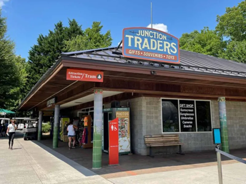 A small cinderblock building with a brown metal roof with a sign that says"Junction Traders Gift Shop."