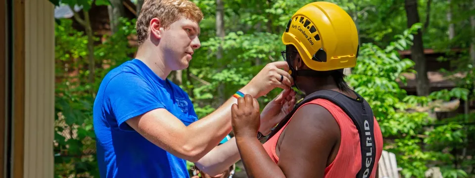 Seasonal staff helping get guests ready for Air Hike ropes course