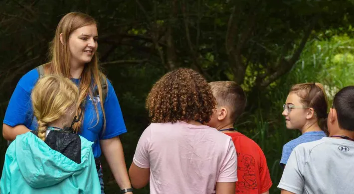 camp counselor talking with campers 