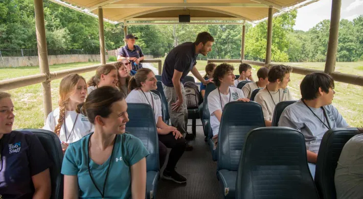 A group of students viewing animals from the Zoofari bus as part of their Wild Science Camp experience. 