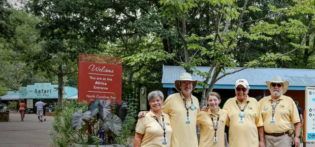 Five Zoo volunteers posing for the camera in Africa Plaza.