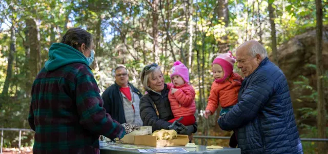 Grandparents with their twin grandchildren visit an investigation station.