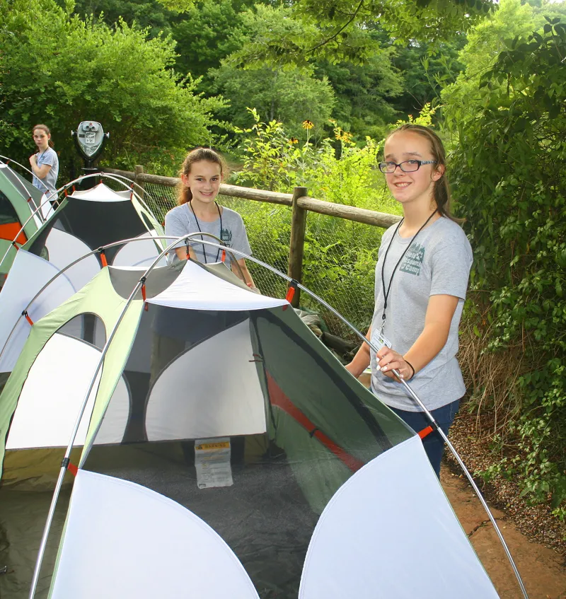 Young girls pitching tents at a Snorin' Safari event.